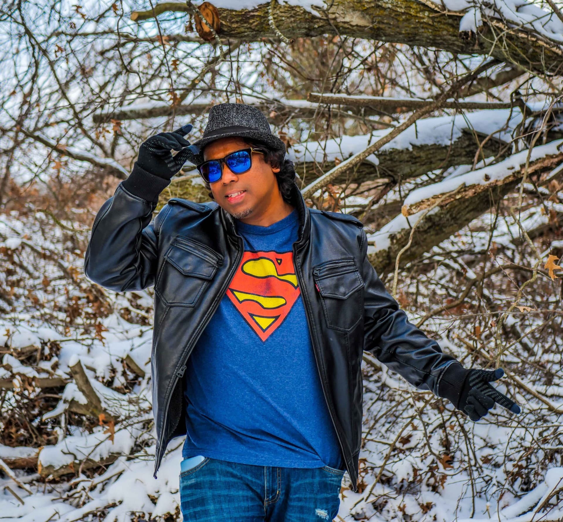 Styled winter portrait in a Superman tee and leather jacket among snow-covered branches